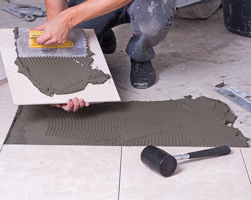 Installant des carreaux au sol